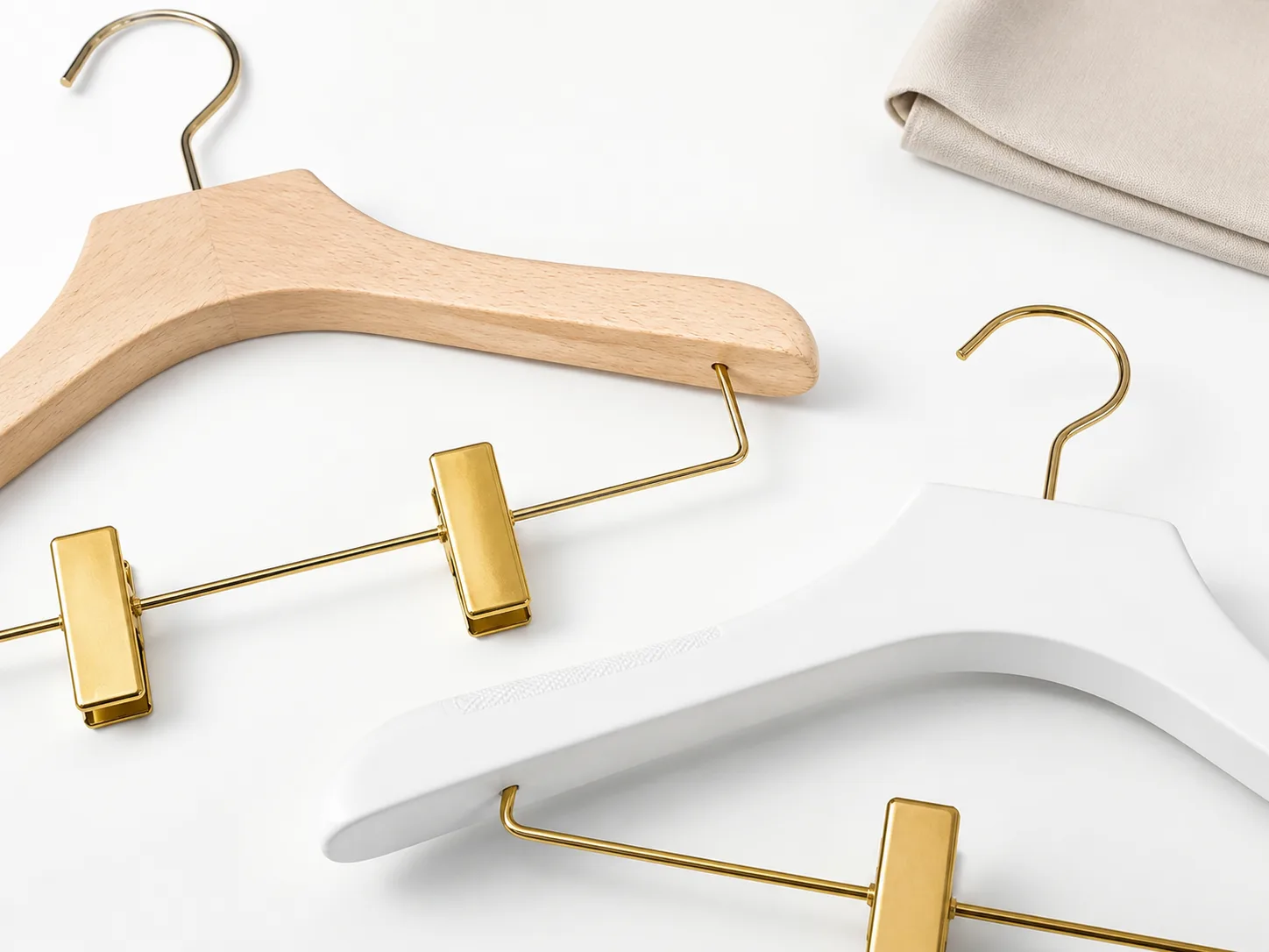 Matte white womens hangers with gold clips in a boutique